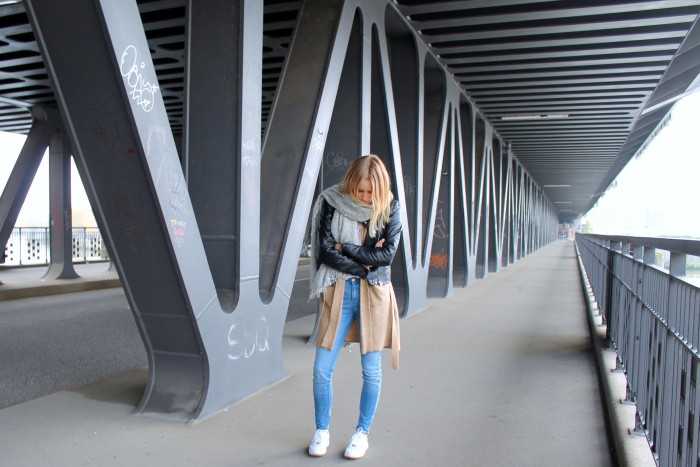 Schwarze Jacke mit beigem Cardigan und Jeans