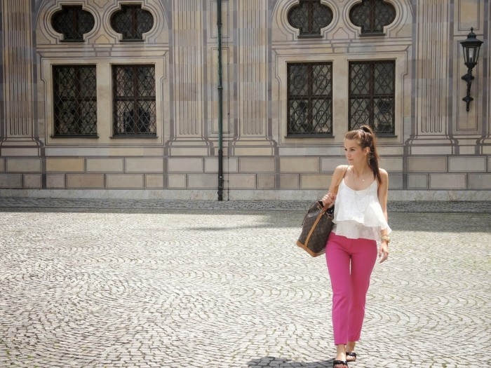 Brünettes Model trägt ein weißes Top zu einer Pinken Hose